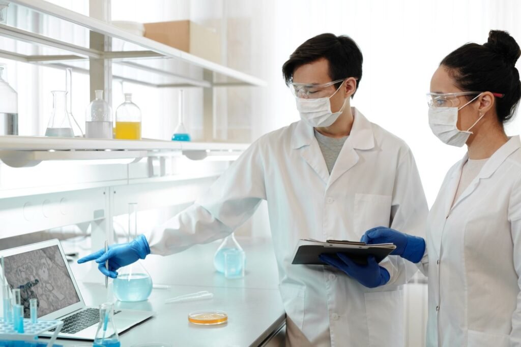Two scientists in a laboratory reviewing data on a computer