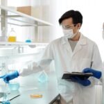 Two scientists in a laboratory reviewing data on a computer